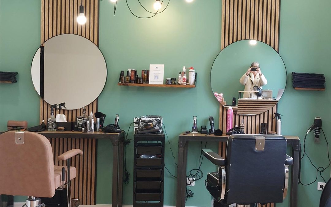 Nouveau salon de coiffure au style naturel, avec murs verts et mobilier bois et métal