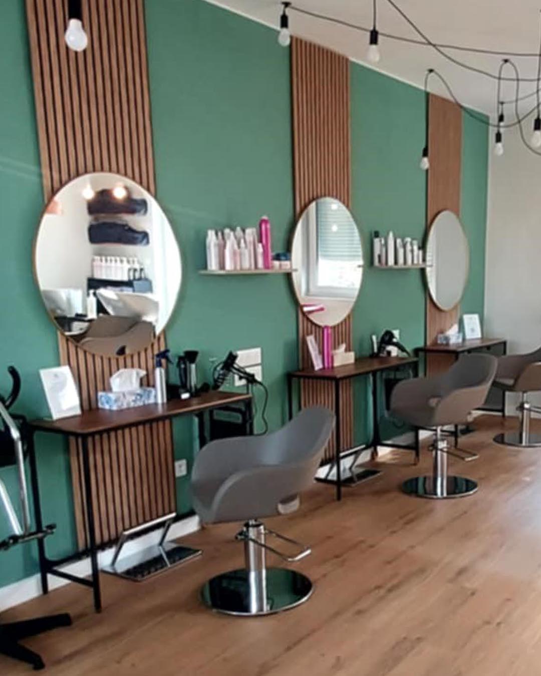 L'espace coiffure du nouveau salon aux murs verts et bois